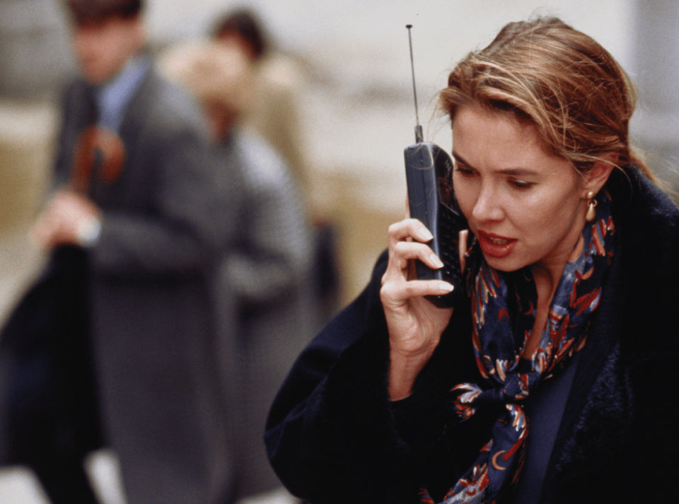 A woman dons a chic black coat, reflecting the iconic 1980s style characterized by bold silhouettes and innovative fashion choices.