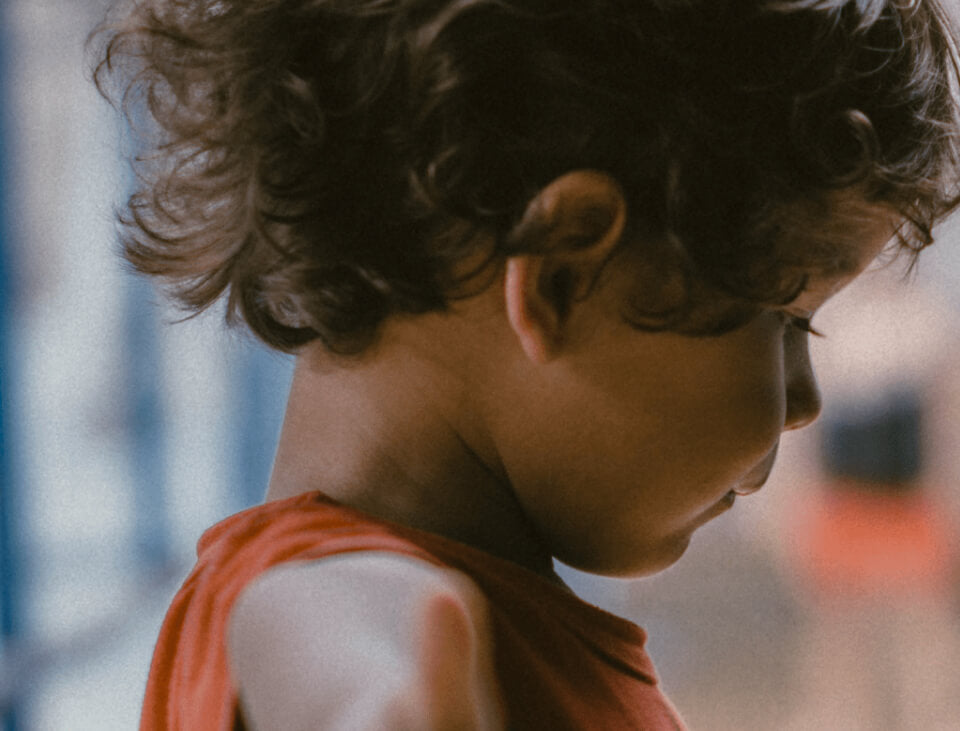 A young boy with curly hair gazes out the window, reflecting the 90s emphasis on children's needs and innovative safety solutions.